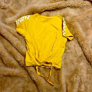 Yellow top with checkerred sleeves.  Tie at bottom front